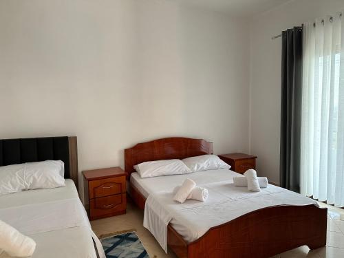 a bedroom with two beds and a window at Vila 44 in Sarandë