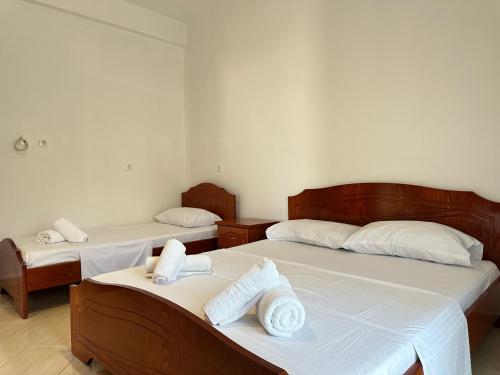 two beds in a room with towels on them at Vila 44 in Sarandë