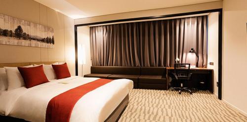 a hotel room with a bed and a couch at Best Western Plus Jeonju in Jeonju