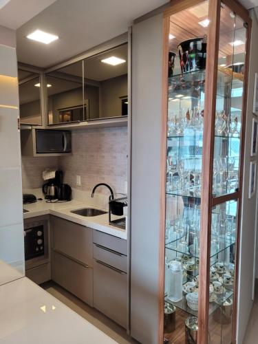 une cuisine avec une vitrine avec de la vaisselle dans l'établissement Flat beira mar com estacionamento apto 1515, à Balneário Camboriú