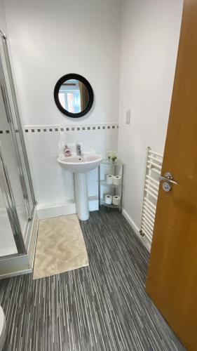 a bathroom with a sink and a mirror at Stylish spacious 2 bed Apt Balcony Nr City Stadium in Manchester