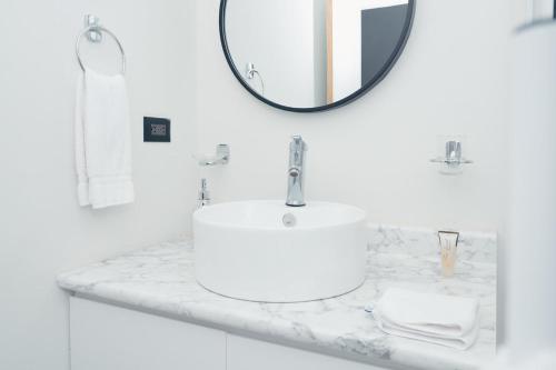 a white bathroom with a sink and a mirror at Santa Rita apartament#4 near restaurants in Danlí