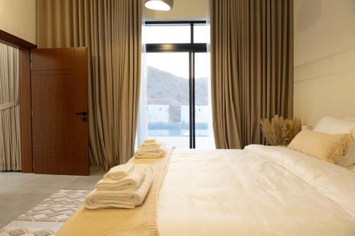 a hotel room with two beds with towels on them at Sifah Breeze in Dhīqdah