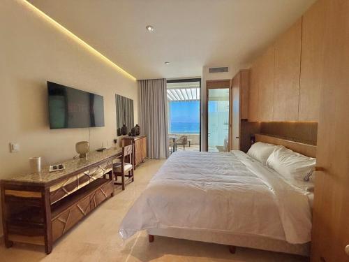 a bedroom with a bed and a desk with a view at Zantamar Penthouse 603B, right on the beach in Cruz de Huanacaxtle