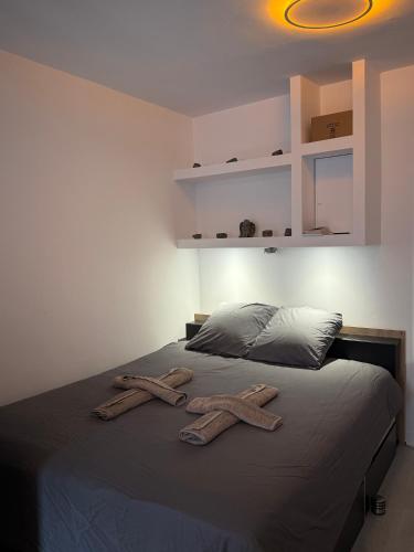 deux serviettes sur un lit avec deux croix dessus dans l'établissement Le temple, moderne et élégant Cœur de Limoges, à Limoges