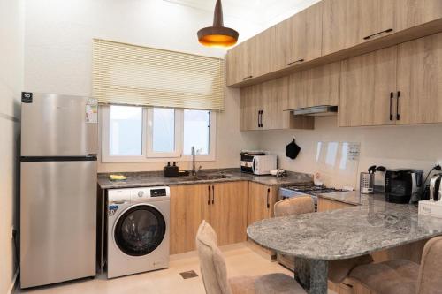 a kitchen with a stainless steel refrigerator and a table at Sifah Breeze in Dhīqdah