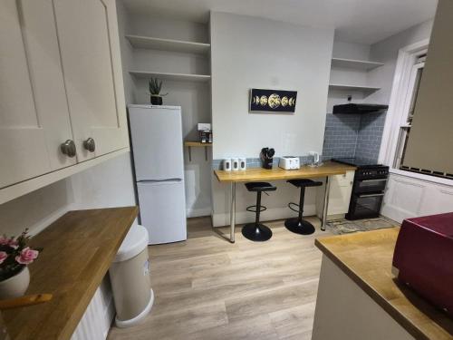 a kitchen with a white refrigerator and a table at Spacious Apartment in London in London