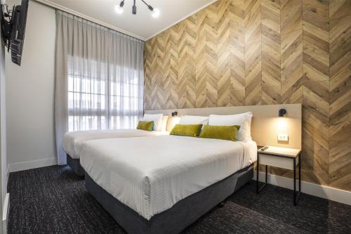 a bedroom with a large bed and a window at Nightcap at Sylvania Hotel in Campbellfield