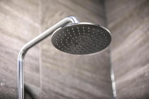 a shower head in a shower stall at Nightcap at Sylvania Hotel in Campbellfield