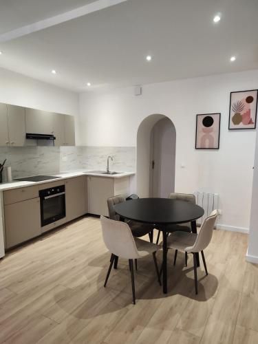 une cuisine et une salle à manger avec une table et des chaises dans l'établissement Appartement Confort Cholet, à Cholet