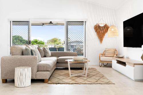 a living room with a couch and a table at Unit 4 Tuscany Shores in Marcoola