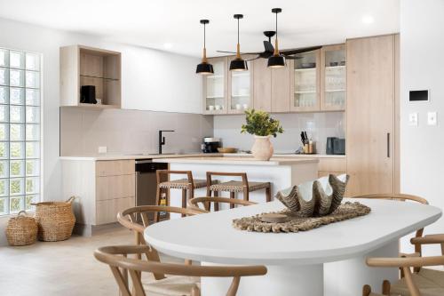 a kitchen and dining room with a white table and chairs at Unit 4 Tuscany Shores in Marcoola