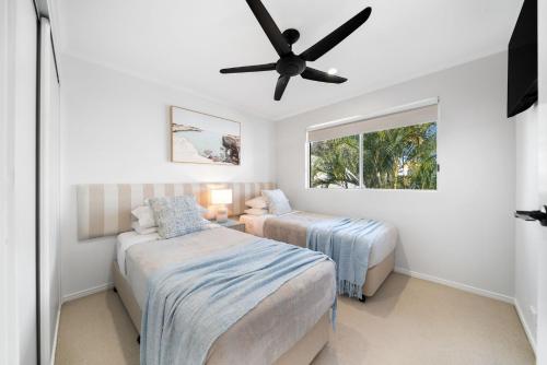 a bedroom with two beds and a ceiling fan at Unit 4 Tuscany Shores in Marcoola