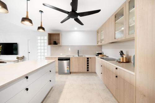 a kitchen with white cabinets and a ceiling fan at Unit 4 Tuscany Shores in Marcoola