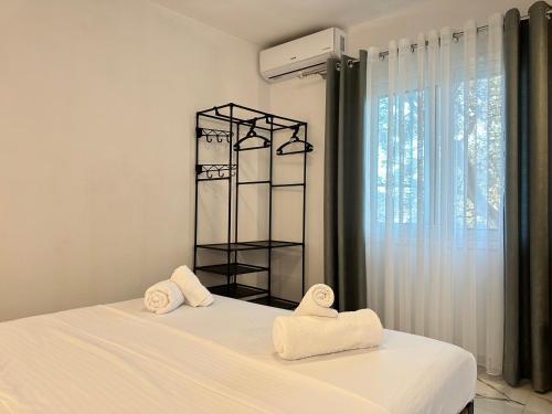 a bedroom with two towels on a bed with a window at Vila 44 in Sarandë