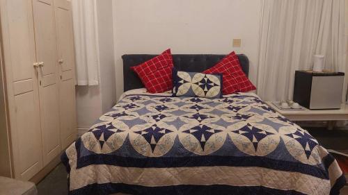 a bedroom with a bed with red pillows on it at The Wellstead in Cape Town