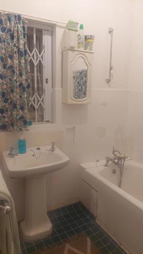 a bathroom with a sink and a bath tub at The Wellstead in Wynberg