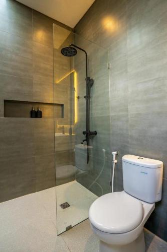 a bathroom with a toilet and a glass shower at Villa Casa Sea Salt in Denpasar