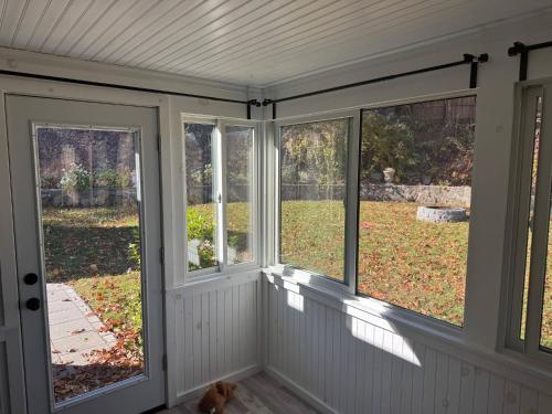 an empty screened porch with a view of a yard at Oscawana Lake Escape in Putnam Valley
