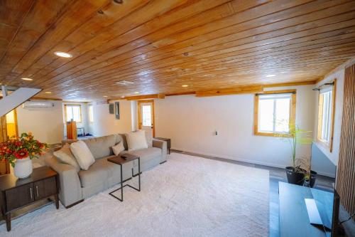 a living room with a couch and wooden ceiling at Oscawana Lake Escape in Putnam Valley