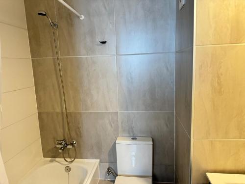 a bathroom with a white toilet and a shower at Muelle Barón - Terminal de Buses in Valparaíso