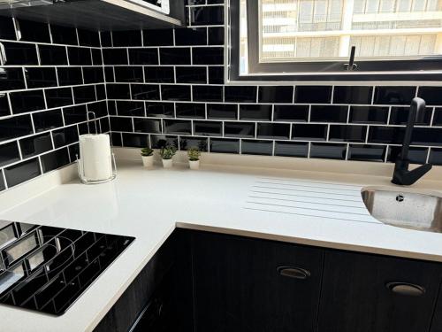 a black and white kitchen with a sink and a counter at Muelle Barón - Terminal de Buses in Valparaíso