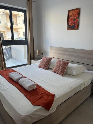 a bedroom with a large bed with pillows and a window at Cozy and Bright Central Room, Shared Flat in Msida