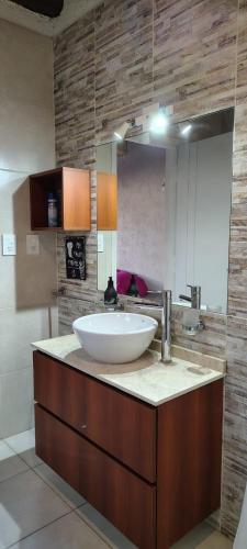 a bathroom with a sink and a large mirror at Los Aromos'home in Chacras de Coria