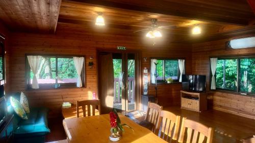 a dining room with a table and chairs and windows at Casablanca Vacation House Sea View Pet OK Billiards カサブランカ 海の見える ペット可 ビリヤード 本部町 in Motobu