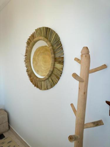 a mirror on a wall next to a wooden stick at Eco Bay Surf Camp in Aourir