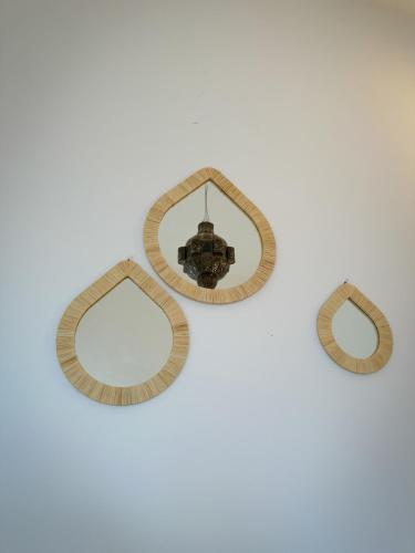 a group of three mirrors on a white wall at Eco Bay Surf Camp in Aourir