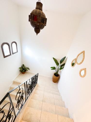 a staircase in a house with a chandelier at Eco Bay Surf Camp in Aourir