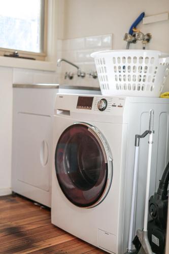 a washing machine in a kitchen next to a sink at StayAU Newly Modern Comforts 3BRM Home Cranbourne in Cranbourne