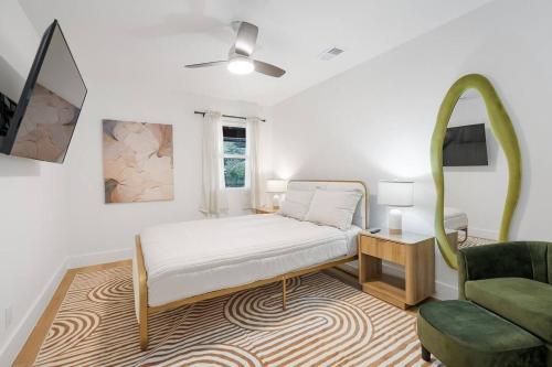 a bedroom with a bed and a green chair at Stylish Austin Escape 4BR, 2BA, Minutes from Domain, Q2 Stadium in Austin