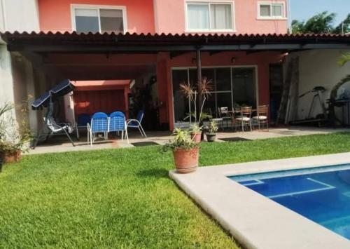 a backyard with a pool and a house at Casa Colibrí Ahuatepec Cuernavaca in Cuernavaca