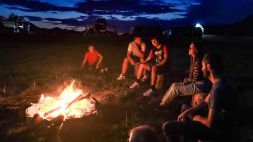 a group of people sitting around a fire at Transylvania Undiscovered 