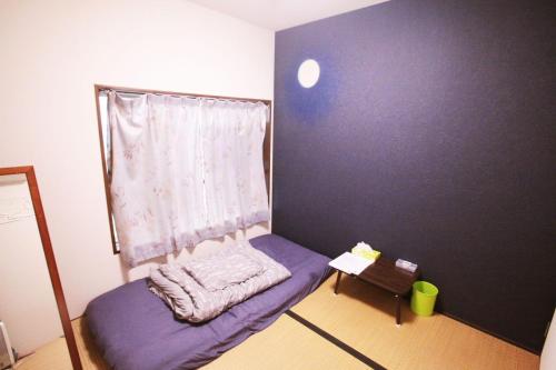 a small bedroom with a purple bed and a window at 2F - Vacation STAY 41690v in Okinawa City
