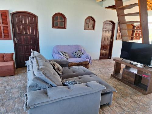 バーハ・デ・サン・ジョアンにあるCasa Aconchegante com Vista para o Mar em Rio das Ostrasのソファとテレビのあるリビングルーム