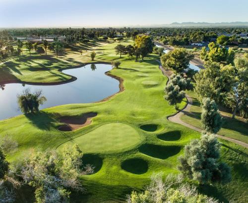 an aerial view of a golf course with a pond at Holiday Inn Express & Suites - Gilbert - East Mesa by IHG in Gilbert