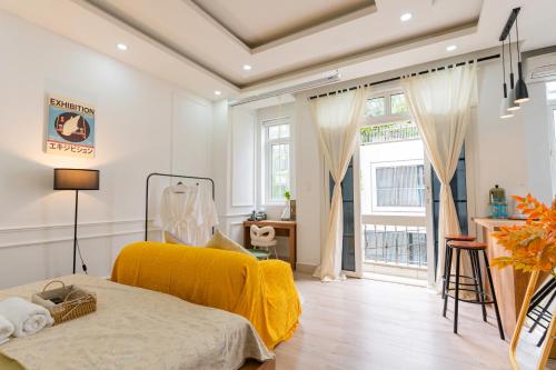 une chambre avec un lit avec une couverture jaune dans l'établissement NamiStay Sài Gòn Central Home, à Hô-Chi-Minh-Ville