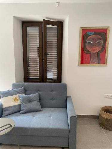 a blue couch in a living room with a painting at Botique Studio - Casa El Sueño in Vodnjan