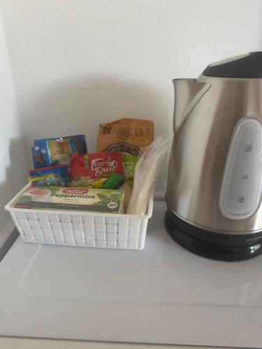 a basket of snacks next to a tea kettle at Pearl of the City TROPICAL PEARL in Kingston