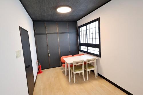a dining room with a table and chairs and a window at Manabi-stay Takayama SAKURA in Takayama