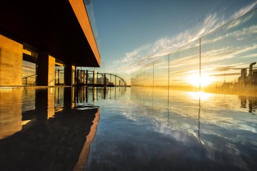 a reflection of the sun in the water of a building at Hotel Indigo Madrid - Gran Vía by IHG in Madrid