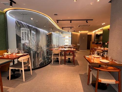 a restaurant with wooden tables and a large wall at Hotel Indigo Madrid - Gran Vía by IHG in Madrid