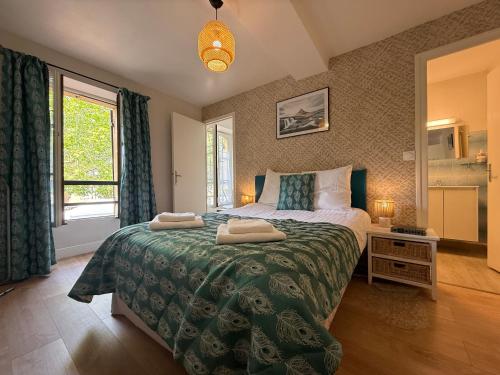 una camera da letto con un letto grande con due asciugamani sopra di Studio Charmant au Coeur d'Excideuil - Animaux Bienvenus - FR-1-839-6 a Excideuil