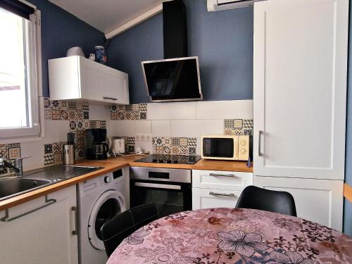 une petite cuisine avec une table et un micro-ondes dans l'établissement Appartement climatisé au cœur de Banyuls-sur-Mer, proche plage - FR-1-309-525, à Banyuls-sur-Mer