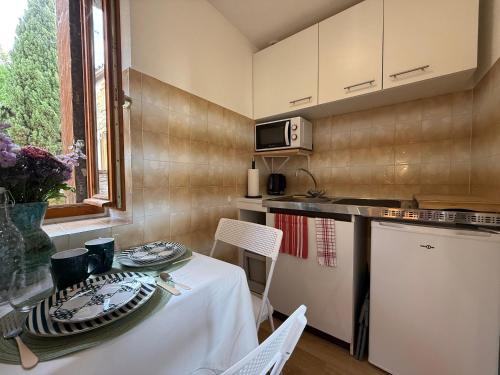 une petite cuisine avec une table et un chiffon de table blanc dans l'établissement Studio chaleureux au cœur d'Excideuil avec wifi et animaux admis - FR-1-839-7, à Excideuil