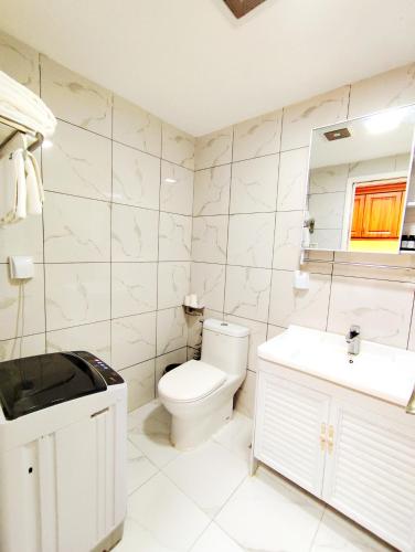 a white bathroom with a toilet and a sink at Guangzhou Zhicheng Leader Tour International Apartment-The Legend Building-FREE SHUTTLE BUS FOR CANTON FAIR-1mins to Line5 STN in Guangzhou