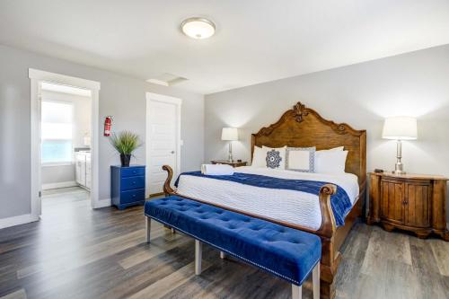 a bedroom with a large bed with a blue bench at Vermijo Flat Walk to Downtown Shops & Dining in Colorado Springs